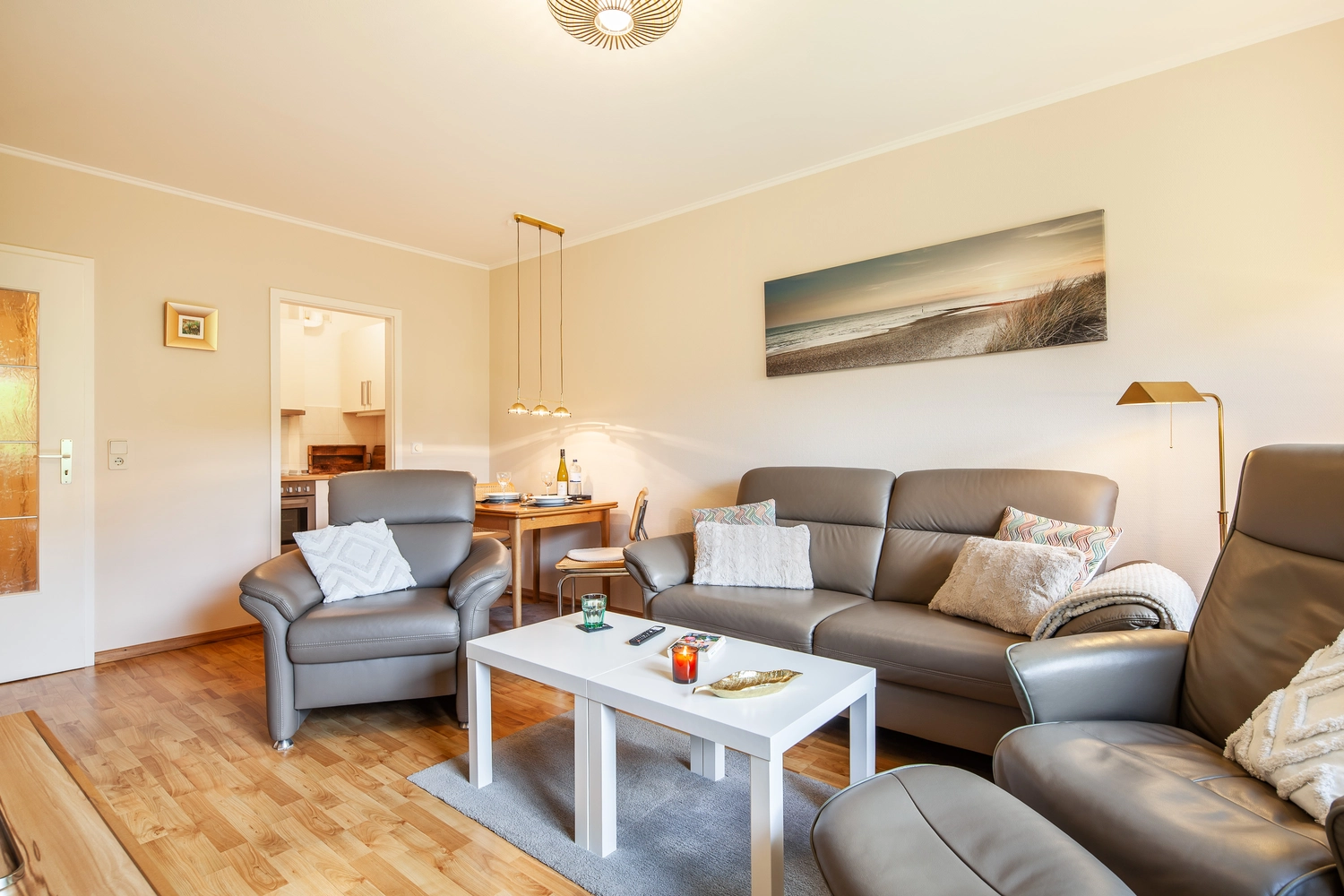 Wohnzimmer mit Ledersofa und Strandbild